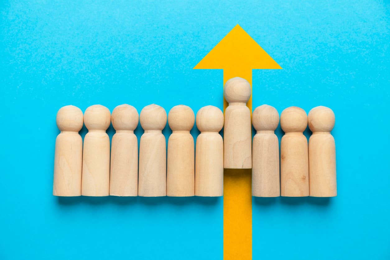 Wooden figures and a yellow arrow on a blue background