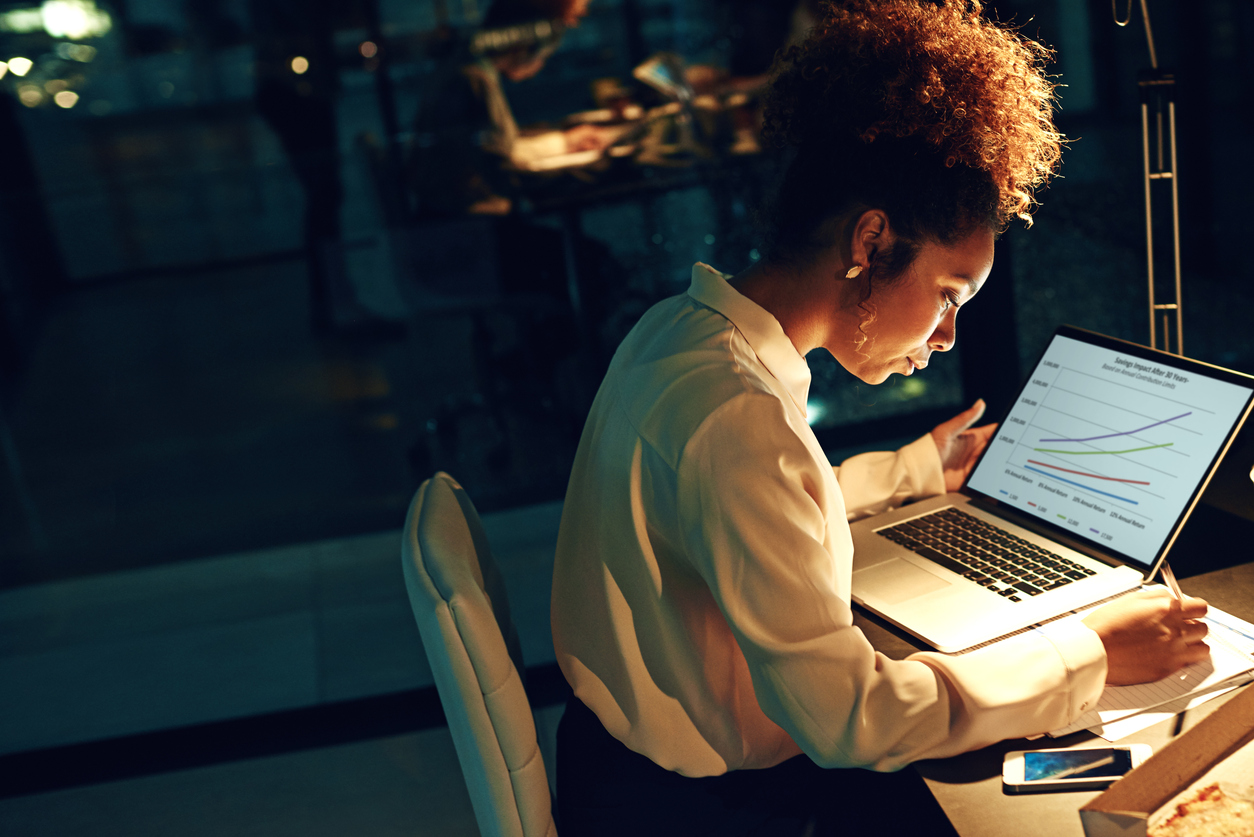 A founder sits at her desk and reviews data as she works to choose the right investors for her business. 