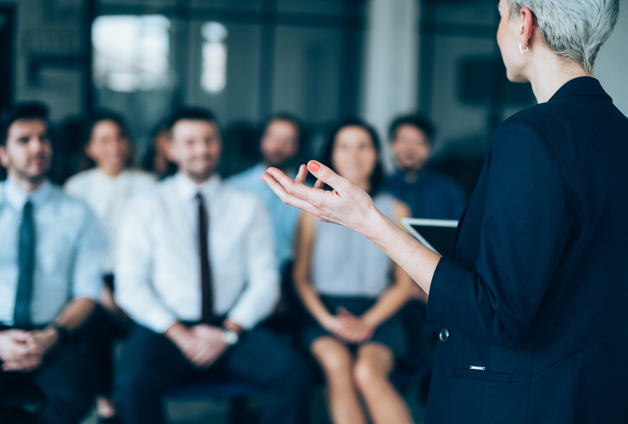 A female corporate leader communicates effectively with her team.