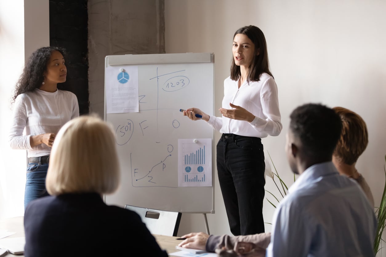 A young businesswoman trains a sales team in a modern office setting