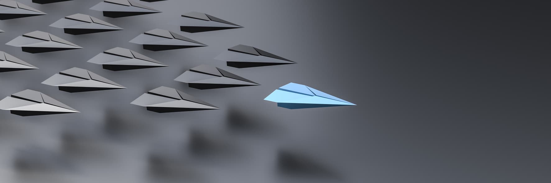 A blue paper airplane leading several black paper airplanes 
